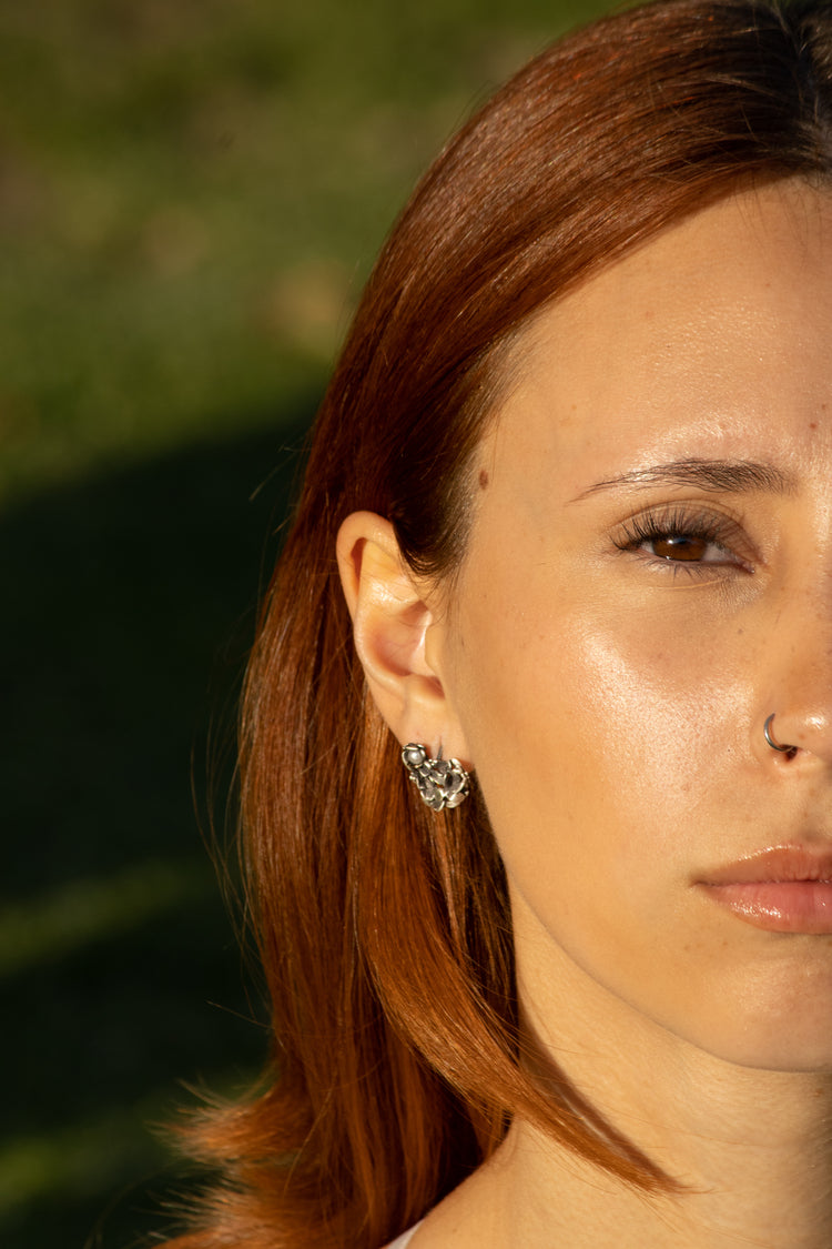 Par de aretes corazón con flores en plata 925. Diseño original hecho a mano de origen mexicano. Aretes en plata 925 hecho a mano por Eva Carrillo Joyas. Diseño de autor.