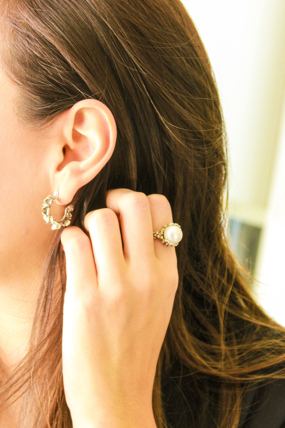 Modelo muestra anillo de plata 925 arrecife con perla blanca y arete hortensia
