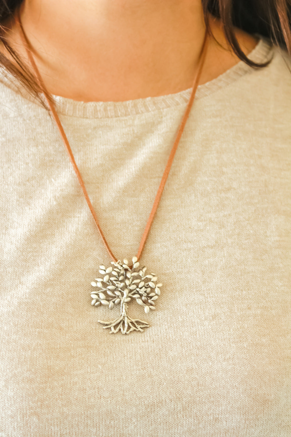 Modelo luce un collar con dije de plata 925 en forma de árbol de la vida