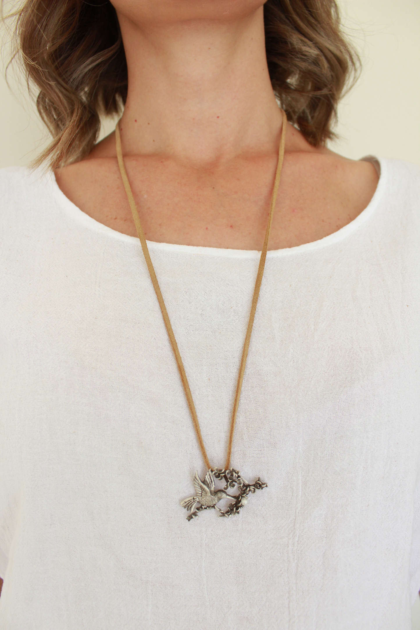 Modelo porta collar largo con dije en plata 925 con forma de colibrí con perla cultivada.