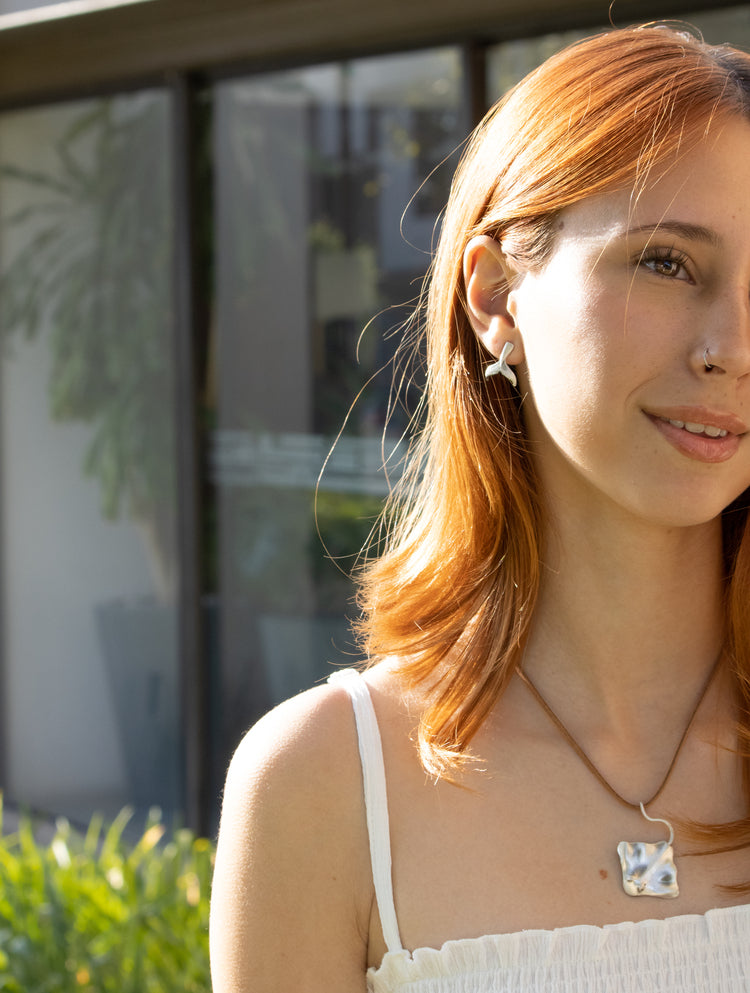 Modelo con colgante Mantarraya y  aretes de cola de ballena en plata 925. Joyería de plata hecha a mano en México. Aretes Cola de Ballena Eva Carrillo Joyas.