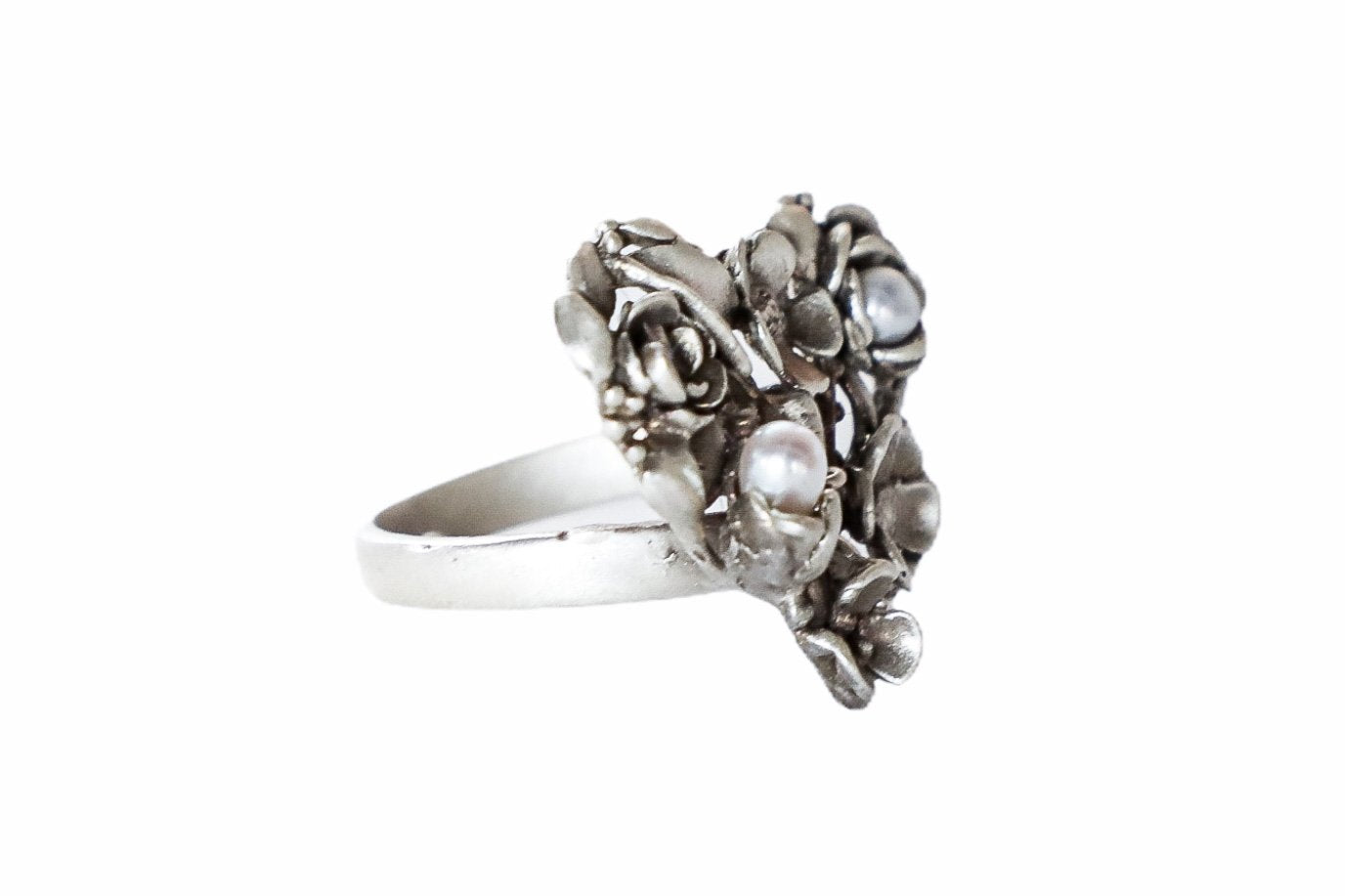 Se muestra de costado el anillo de plata con forma de corazón de flores con 2 perlas cultivadas. Anillo en plata 925, hecho a mano, anillo en plata ajustable.